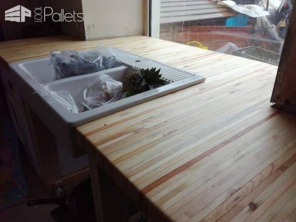 This Pallet Wood Kitchen features an end-grain pallet wood counter top done in a butcher block style.