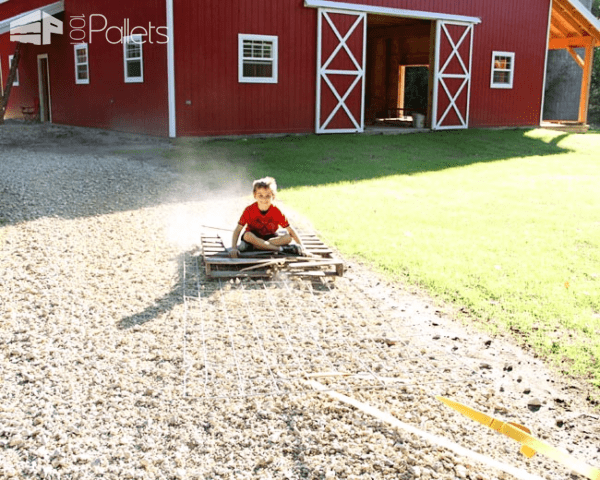 Weird Wood ideas include putting your kids to work as anchors on a pallet drag chain to smooth your driveway.