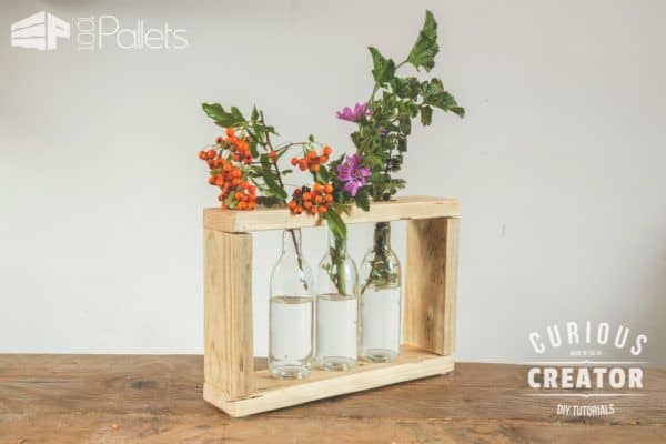 Make this Pallet Glass Vase Stand with the help of the DIY Video Tutorial. Then have fun emptying three clear bottles of your favorite beverage to complete it.