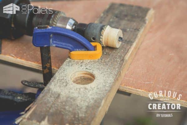 With only a hole saw bit and a drill, along with some clamps, you can quickly make this Pallet Glass Vase Stand.