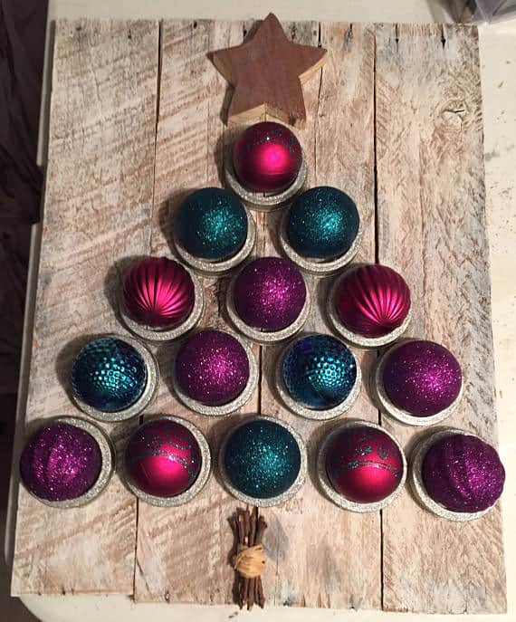 Make a pallet christmas tree by making a pallet back, then gluing sparkly ornaments to the surface for an amazine piece of Pallet Christmas Decor..