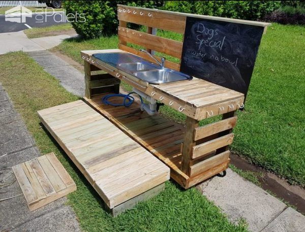 This Pallet Kid's Kitchen features a chalkboard, plenty of hooks for hanging things, a deck and steps.