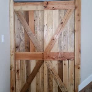 These Pallet Closet Doors are rustic, stylish, and make a dull hallway look extraordinary. Add a custom punched-metal piece on the top and you've got a one-of-a-kind creation that'll set your house apart!